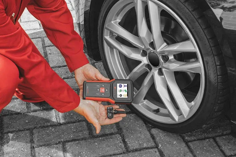 Technician testing a TPMS sensor with a Bartec TPMS tool